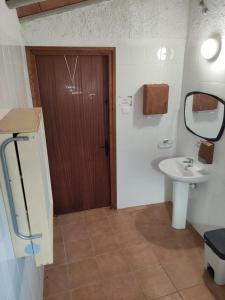 baño con lavabo y puerta de madera en Refugi de Muntanya Els Masets, en La Riba