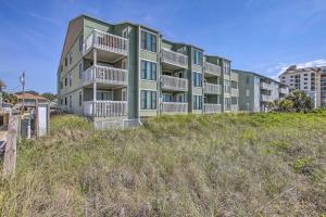 ein Gebäude auf einem Hügel mit hohem Gras in der Unterkunft Walk to Beach Sunny Seaside Condo with View! in Myrtle Beach
