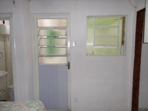 a white room with a door and a window at Hospedagem Progresso in Juiz de Fora +53 photos