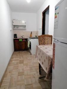 a kitchen with a table and a refrigerator at La Cabana in Băile Herculane