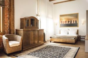 a bedroom with a bed and a chair in a room at BERCHY Apartments MAISON in Liepāja