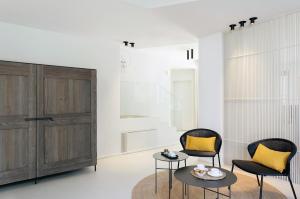a living room with two chairs and a table at Domìa Boutique Hotel e Cucina in Mondello