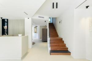 a staircase in a house with white walls and wooden floors at Domìa Boutique Hotel e Cucina in Mondello