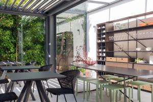 a dining room with tables and chairs and a large window at Domìa Boutique Hotel e Cucina in Mondello
