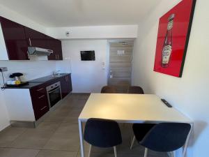 a kitchen with a table and chairs in a room at Hôtel L'Escale Coté Port in LʼÎle-Rousse