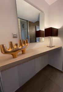 a bathroom with a counter with a mirror and a sink at Hôtel L'Escale Coté Port in LʼÎle-Rousse