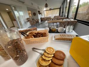 a table with bread and a basket of pastries on it at Hôtel L'Escale Coté Port in LʼÎle-Rousse