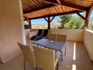 a patio with a table and chairs on a balcony at Hôtel L'Escale Coté Port in LʼÎle-Rousse
