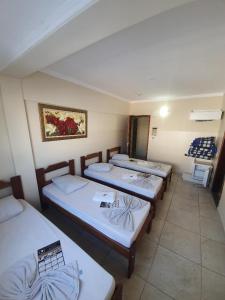 a group of four beds in a room at Hotel dos Devotos in Aparecida