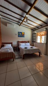 1 dormitorio con 2 camas y ventana grande en Moana Ilhabela en Ilhabela