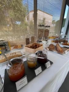 a table with various food items on it at Hôtel L'Escale Coté Port in LʼÎle-Rousse