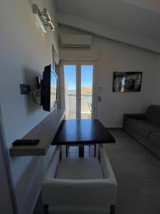 a living room with a table and a couch at Hôtel L'Escale Coté Port in LʼÎle-Rousse
