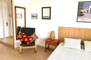 een slaapkamer met een bed, een stoel en een spiegel bij Modern & Spacious Studio Isla, Puerto Del Carmen in Tías