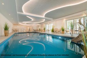 - une piscine dans un bâtiment avec une grande piscine dans l'établissement Ferienhaus II Wiesenblick, à Grömitz