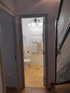 a bathroom with a toilet and a window and a doorway at Al Alba Vivienda Vacacional VV1865AS in Illas +20 photos