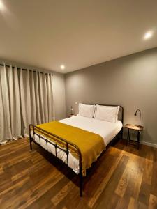 een slaapkamer met een groot bed en een gele deken bij Fátima Host 3AP6 in Fátima