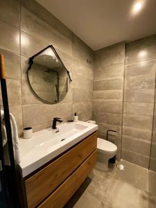 een badkamer met een wastafel, een toilet en een spiegel bij Fátima Host 3AP6 in Fátima