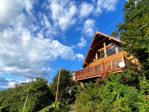 ein Baumhaus mit einer Terrasse auf einem Hügel in der Unterkunft A Private Log House with Mt Fuji View & Piano - "Thangtong House Japan" in Kannami