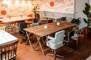 un grande tavolo in legno con sedie in un ristorante di Selina Brighton a Brighton & Hove