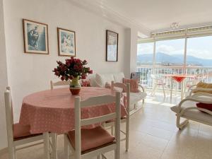 salon ze stołem i wazą kwiatów w obiekcie Coronado 73 Apartments Casasol w mieście Nerja