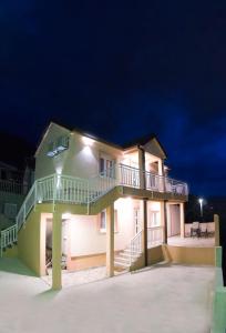a large house with a balcony at night at Apartmani VS Lux in Trebinje