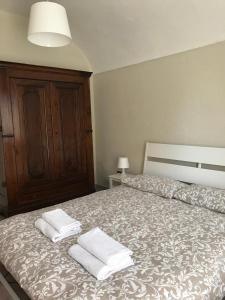 1 dormitorio con 1 cama con 2 toallas en Appartamento i Tulusan a due passi dalle Langhe, en Narzole