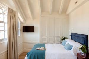 1 dormitorio con 1 cama y TV en la pared en Gran hotel Brillante, en San Esteban de Pravia