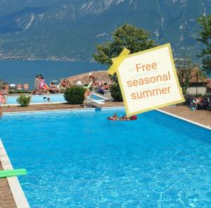 un cartel en una piscina con un cartel de verano gratuito de temporada en Casa Cristina - Vista Lago, en Tignale