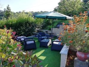 a patio with blue chairs and an umbrella at Hotel La Llosona in Ribadesella +19 photos