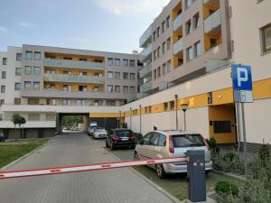 a parking lot with cars parked in front of a building at Apartament SUNtorini in Kołobrzeg