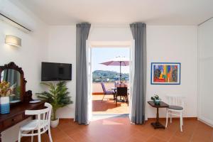 una sala de estar con una puerta que da a un patio con sombrilla en Family Villa in Sorrento Coast Pool & View, en SantʼAgata sui Due Golfi