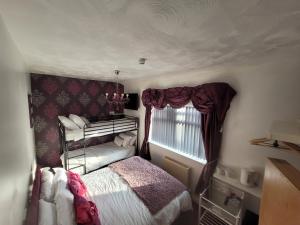 niewielka sypialnia z łóżkiem i oknem w obiekcie Tamarind Cove & Barrons Hotel w Blackpool