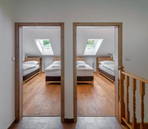 a room with two beds and two windows at Žabinec - penzion, vinotéka in Kurdějov