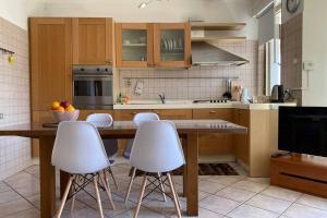 a kitchen with a table and white stools at La Casa di Placido in Pescara