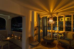 Habitación con balcón con mesa y lámpara de araña. en MARBELLA BANUS SUITES - Iris Tropical Garden Banús Suite Apartment, en Marbella