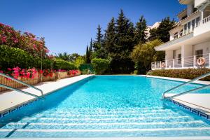 una piscina en medio de una casa en MARBELLA BANUS SUITES - Iris Tropical Garden Banús Suite Apartment, en Marbella