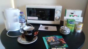 a black table with a microwave and a cup of coffee at Lesley House in Bridgwater