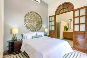 1 dormitorio con cama blanca y espejo grande en Casa Morales Cartagena by Soho en Cartagena de Indias