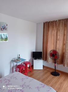 1 dormitorio con 1 cama y 1 mesa con sillas rojas en Vila Lotus, en Murighiol