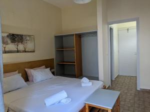 a bedroom with a white bed with two towels on it at Pension Irene in Sougia