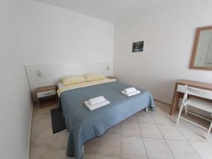 um quarto com uma cama com duas toalhas em Apartmani Plaža em Selce