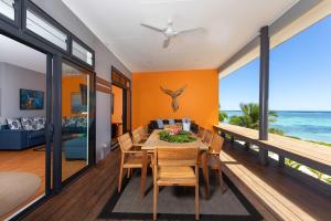 a dining room with a table and chairs and the ocean at Panama Beachfront Apartments, Rarotonga in Rarotonga