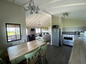 a kitchen and dining room with a large wooden table at Rew Farm Country & Equestrian Accommodation - Sunrise Lodge in Melksham