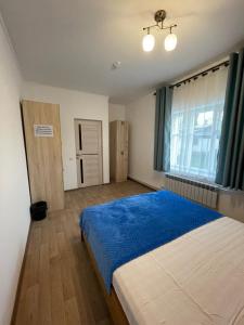 una camera da letto con un letto grande e una finestra di KbH-Karakol based Hostel a Karakol