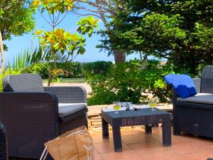 a patio with chairs and a table with wine glasses at Hôtel SOLE E MARE in Saint-Florent
