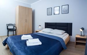 una camera da letto con un letto blu con sopra degli asciugamani di Apartament Władysławowo a Władysławowo