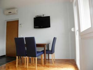 d'une table à manger avec des chaises et une télévision murale. dans l'établissement Apartment in Duce with sea view, balcony, air conditioning, Wi-Fi (4166-3), à Duće