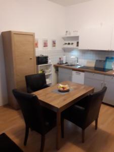 a kitchen with a wooden table and chairs with a plate of food on it at Ferienwohnung Chemnitz - Kaßberg in Chemnitz