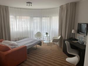 a bedroom with a bed and a living room with a couch at Hotel Blick in Gdynia