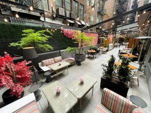 an outdoor patio with tables and chairs and plants at INNSiDE by Meliá New York Nomad in New York